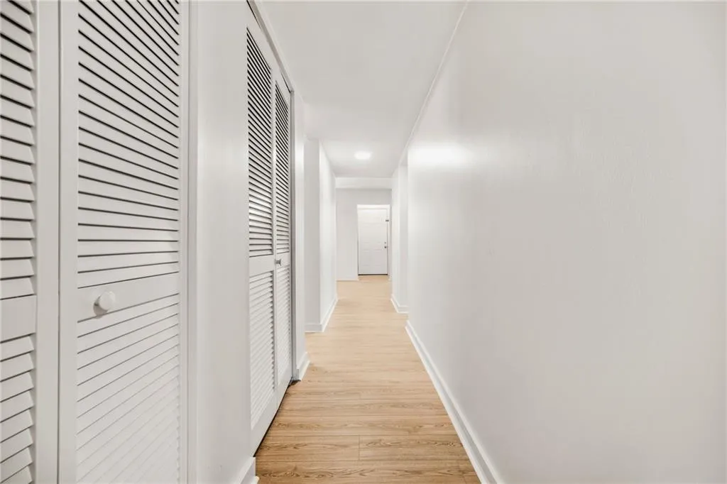 Hallway with light wood-style flooring and recessed lighting