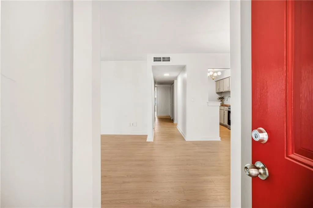 Foyer with light wood finished floors and hanging lights