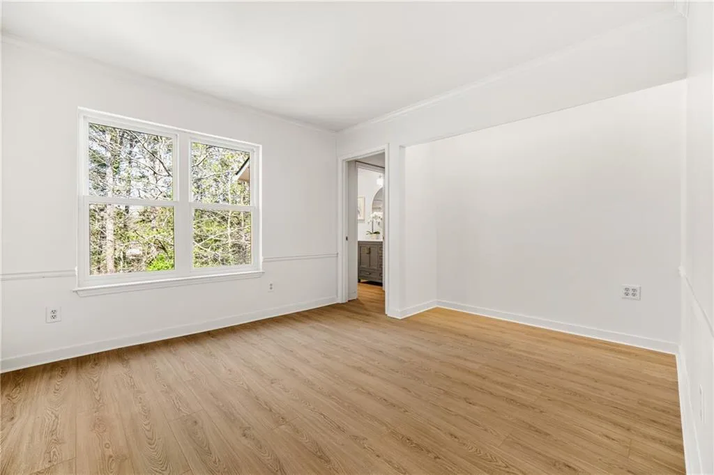 Spare room with light wood finished floors and ornamental molding