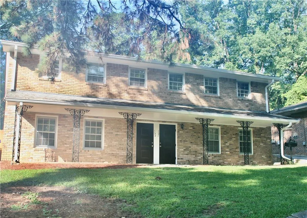View of front of property featuring a front yard and brick siding