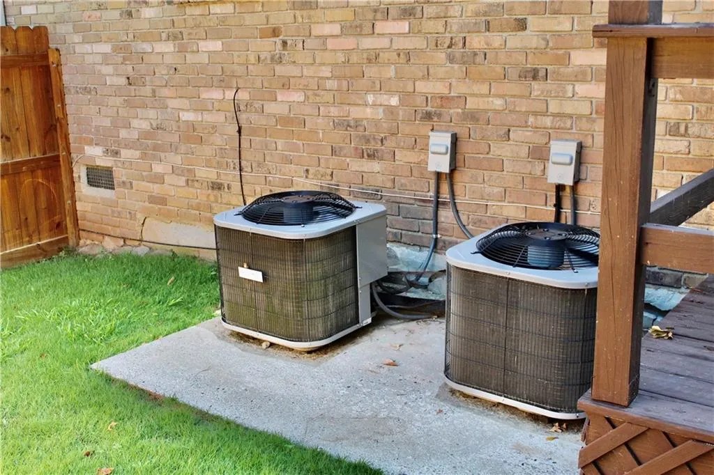 Exterior view of a cooling unit and brick siding