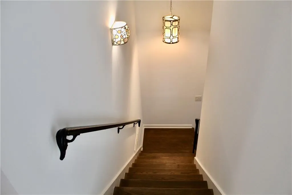 Stairs with wood finished floors and baseboards