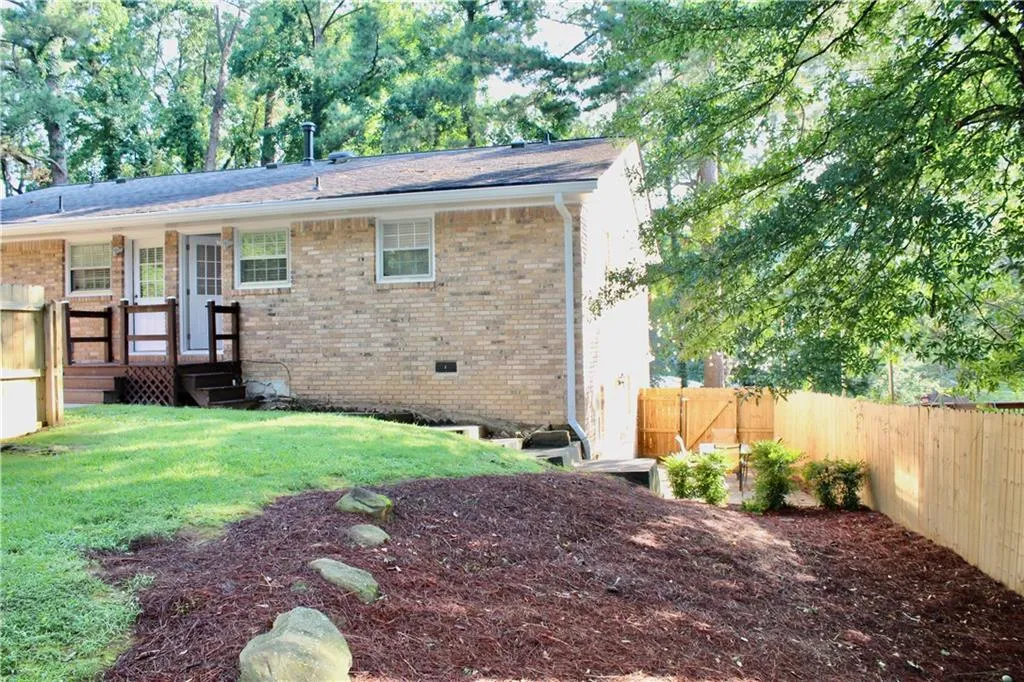 Back of house featuring a fenced backyard and brick siding