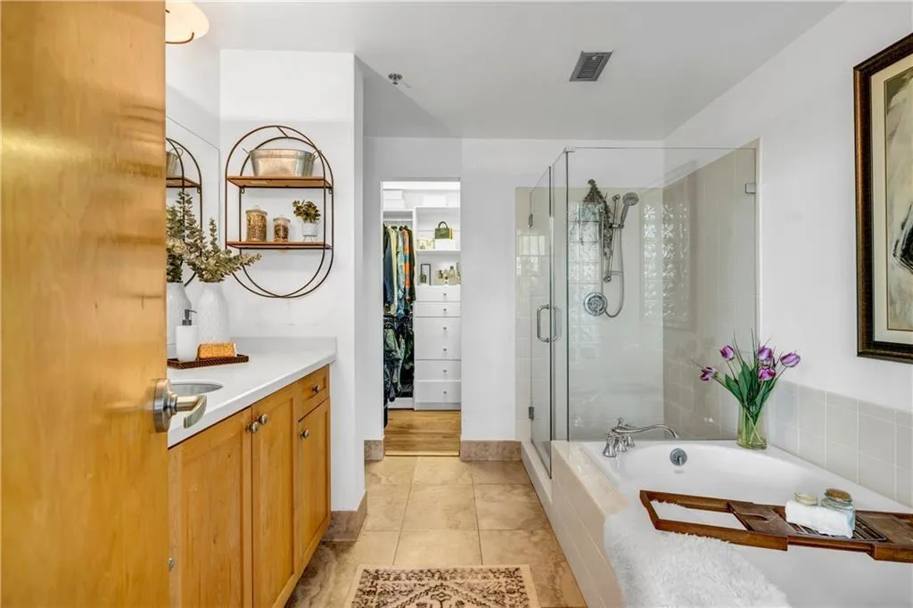 Bathroom featuring vanity, a stall shower, a bath, tile patterned floors, and a spacious closet