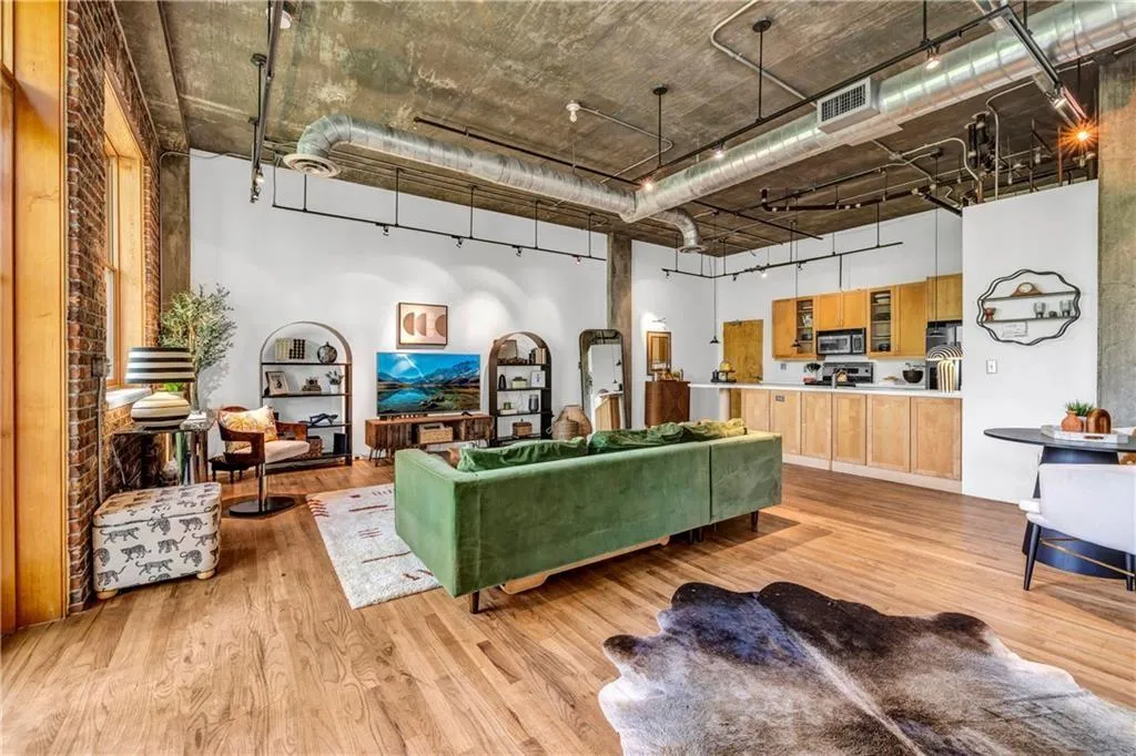 Living room featuring light wood-style floors and a high ceiling