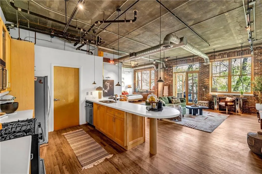 Kitchen with Stainless appliances, a sink, a peninsula, open floor plan, and brick wall