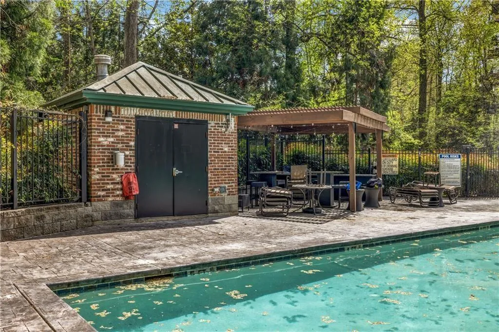 View of swimming pool with a patio, a pergola, and an outdoor structure