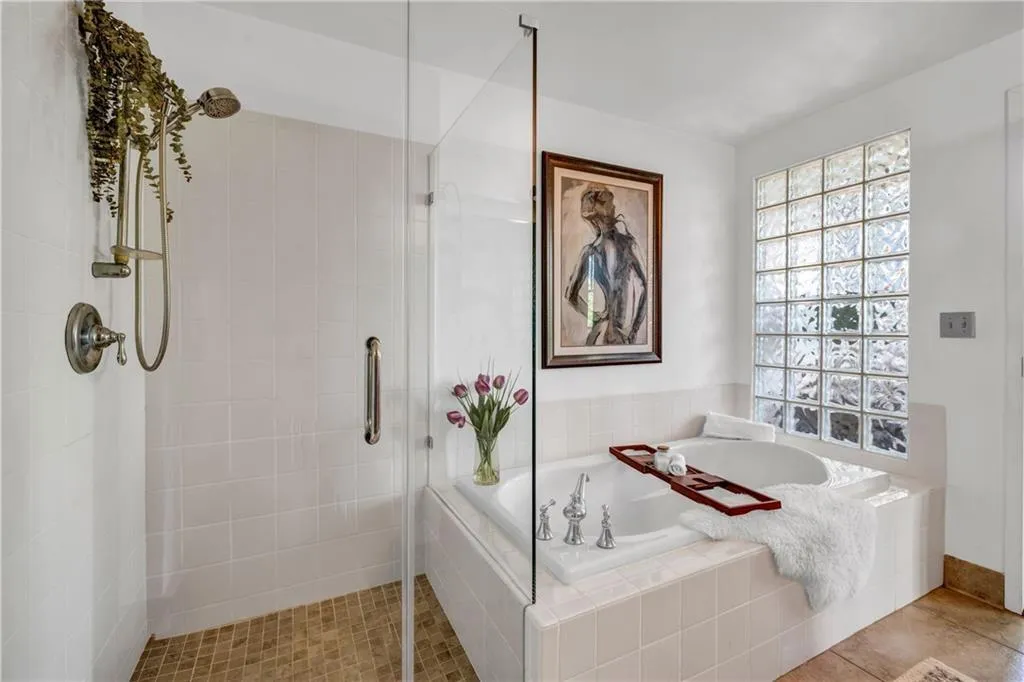 Full bath featuring a shower stall, a garden tub, and tile patterned flooring