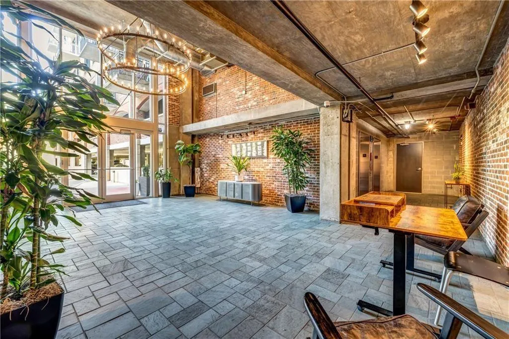 Common area featuring brick wall and a high ceiling