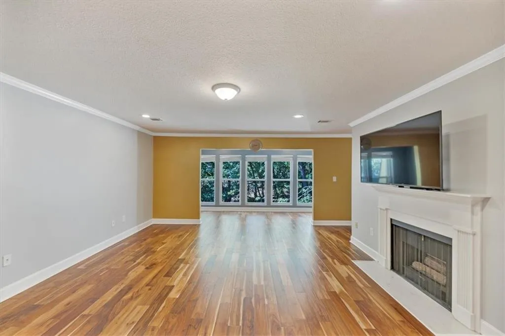 Living room with crown molding, recessed lighting & view straight through to Sunroom