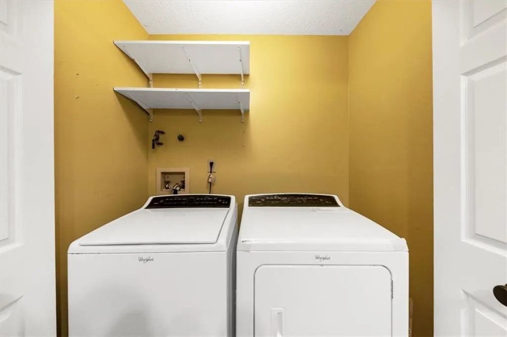 Laundry area featuring washer and dryer and a textured ceiling