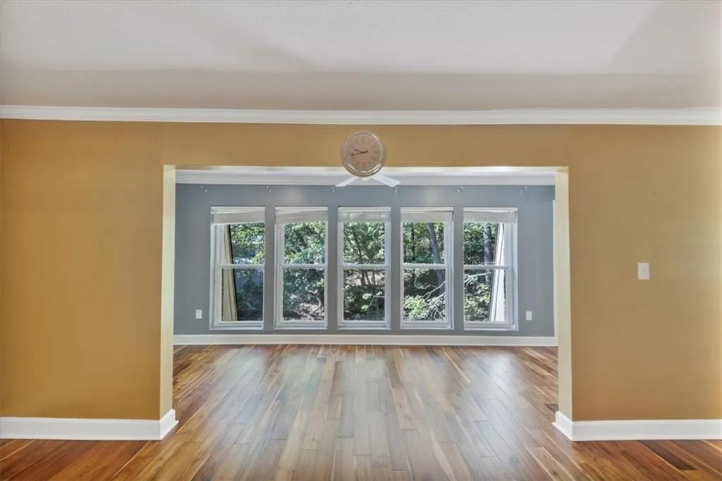 Unfurnished living room with plenty of natural light, crown molding, and hardwood / wood-style floors