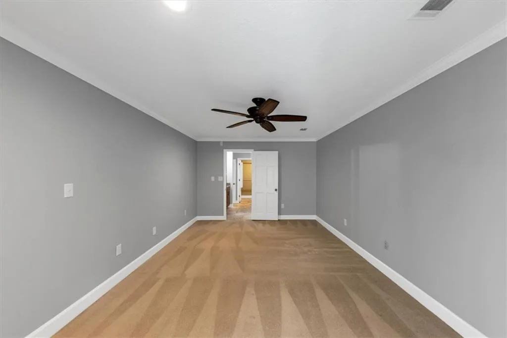 Owner's Bedroom featuring crown molding, light colored carpet, recessed lighting and a ceiling fan