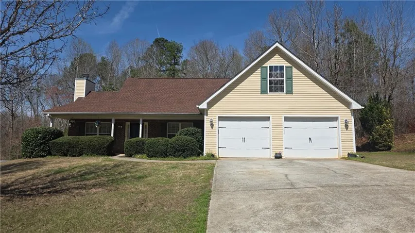 Traditional-style home featuring covered porch, driveway, a front lawn, and a chimney