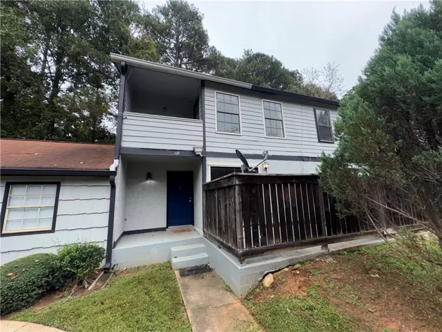 Painted siding exterior with a dark blue entry door