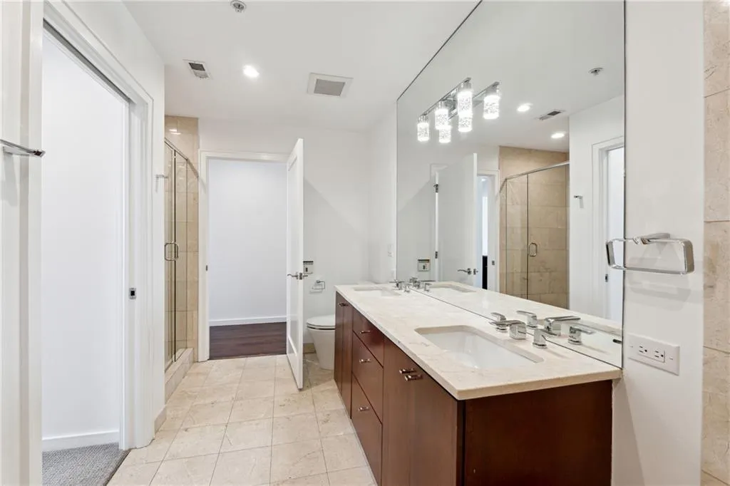 Full bathroom featuring a stall shower, visible vents, and a sink