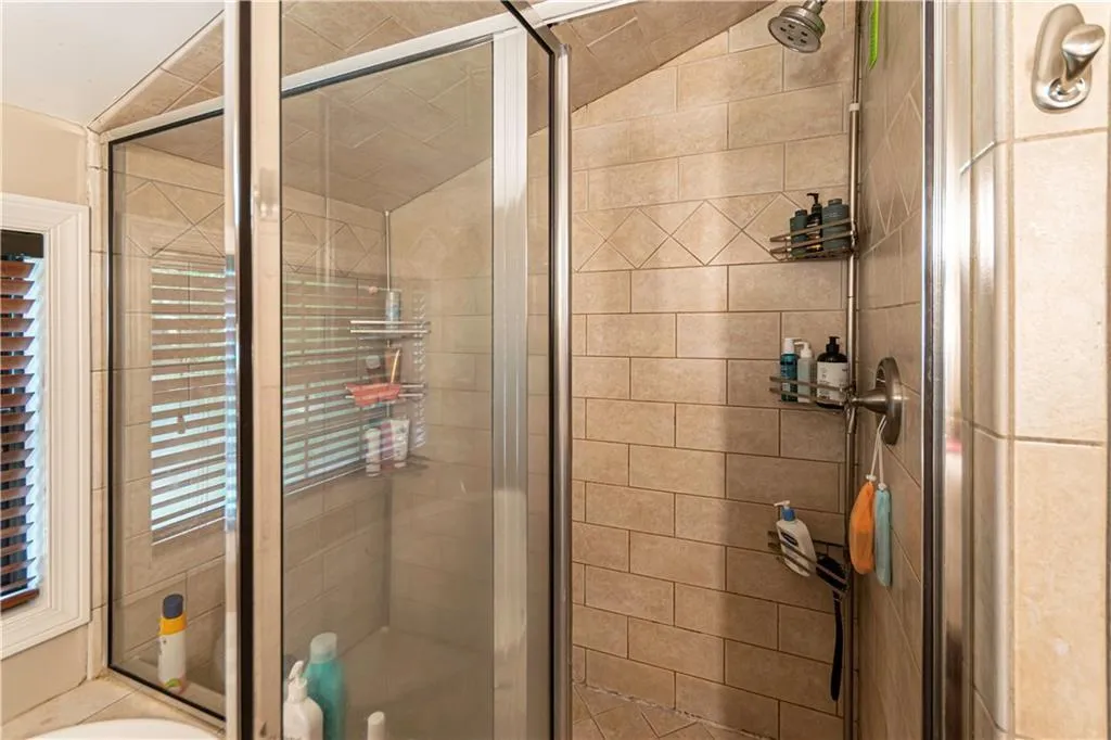 Full bath featuring a shower stall and a tub to relax in