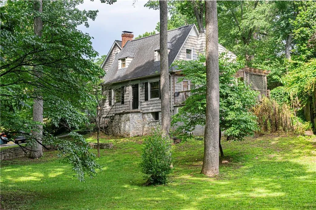 Rear view of house with a lawn and a chimney