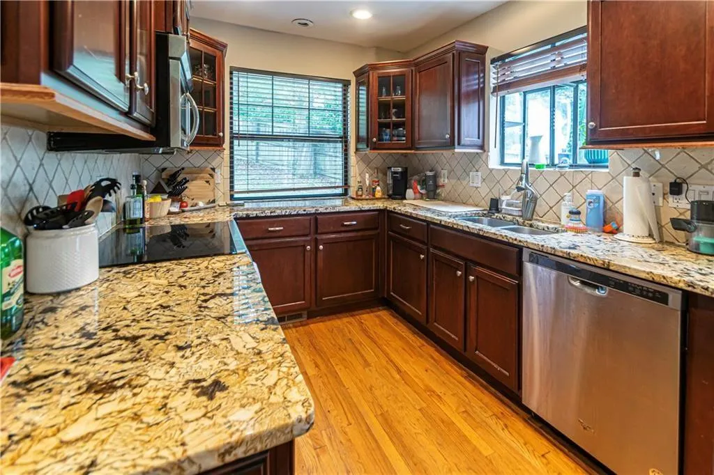 Kitchen featuring stainless steel appliances, healthy amount of natural light, light wood-style floors, tasteful backsplash, and recessed lighting