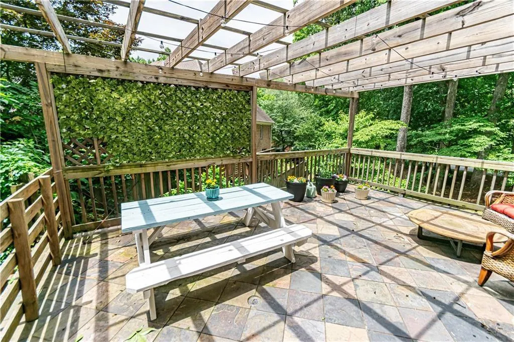 Deck with a pergola, outdoor dining space, and a patio area