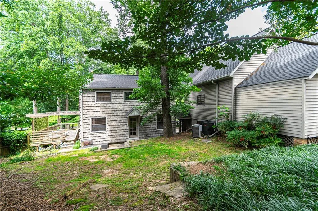 Back of house with a wooden deck and a shingled roof