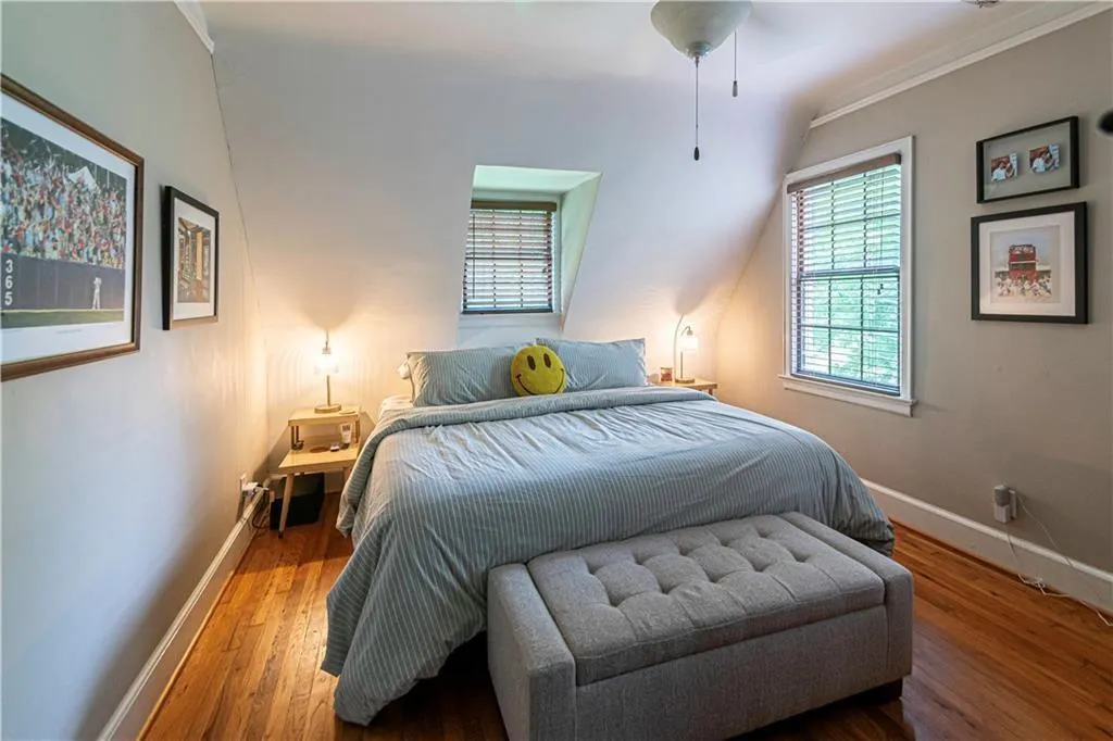 Bedroom with wood finished floors and ornamental molding