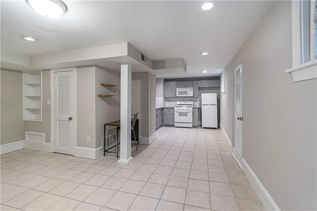 Kitchen featuring white appliances, gray cabinetry, recessed lighting, light tile patterned floors, and built in shelves