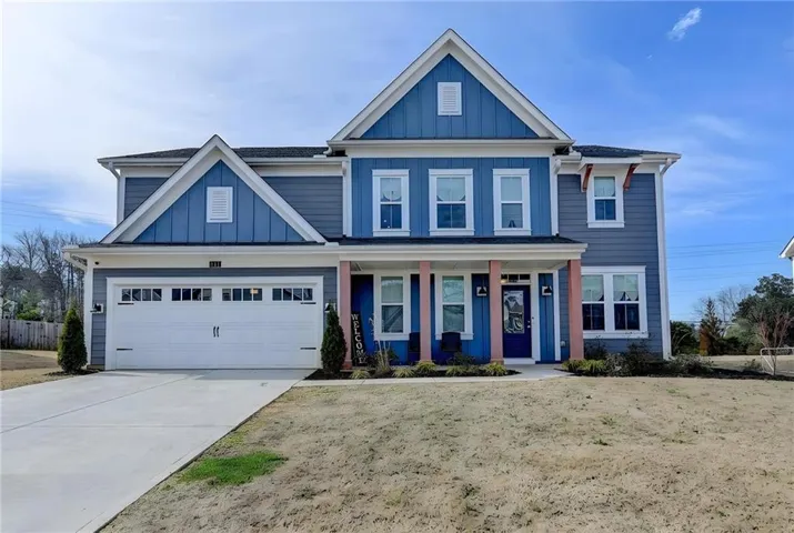 View of front of property featuring board and batten siding, a porch, concrete driveway, a garage, and roof with shingles