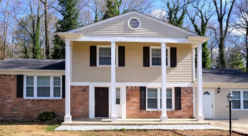 View of front of property with covered porch and brick siding
