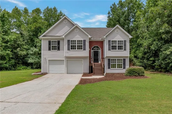 Split-level home featuring vinyl siding and a brick facade accent
