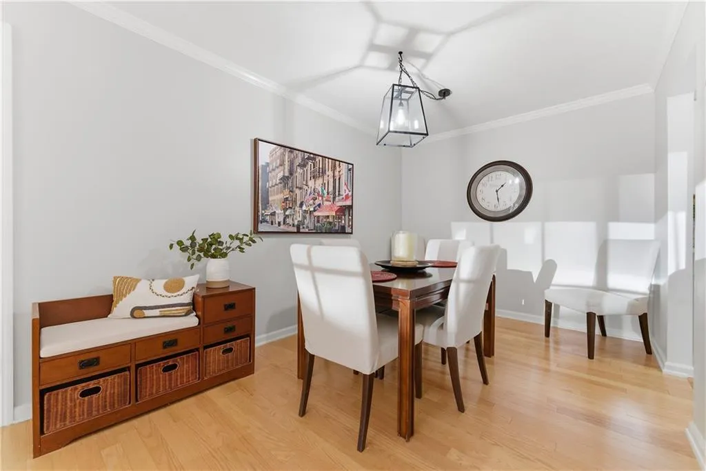 Dining area with ornamental molding and light wood-style floors
