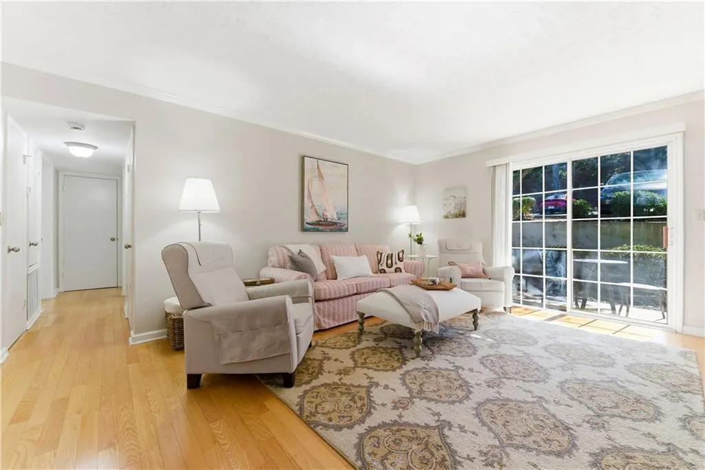 Living room with light wood-type flooring and ornamental molding