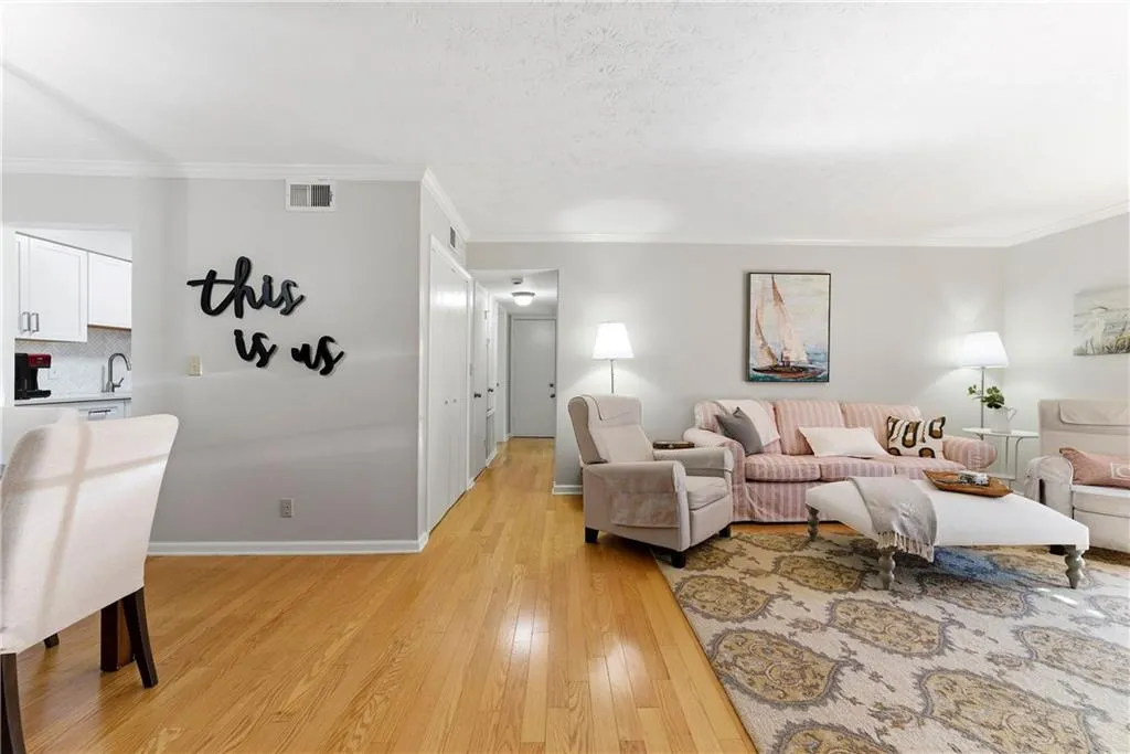 Living room with light wood-type flooring and crown molding