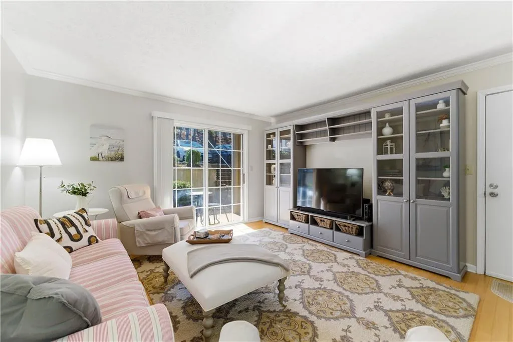 Living area with ornamental molding and light wood-style flooring