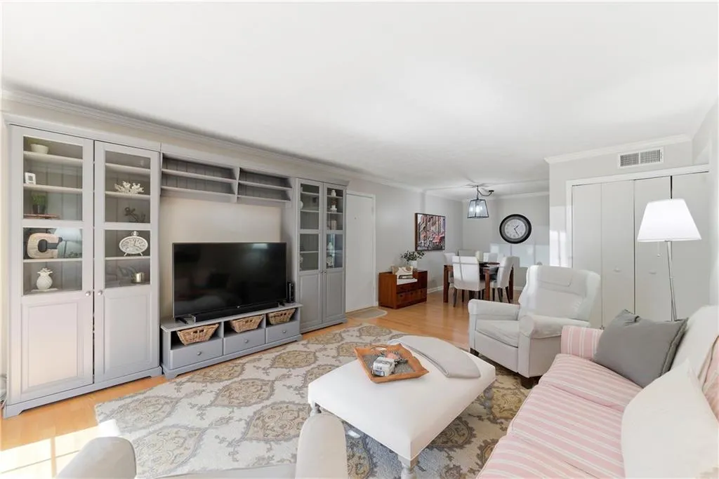 Living room featuring light wood-style floors and crown molding