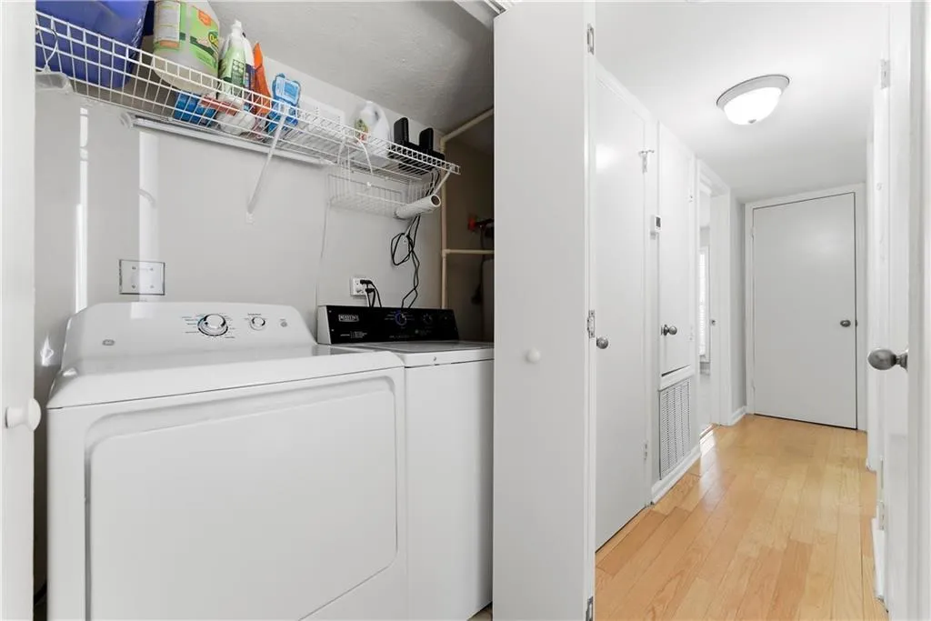 Laundry area with light wood-style flooring and washing machine and dryer