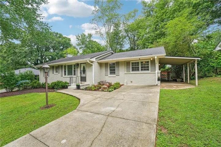 Angled front facing shows the curve of the sidewalk, the landscaping, and the flagstone walkway to the carport/side porch