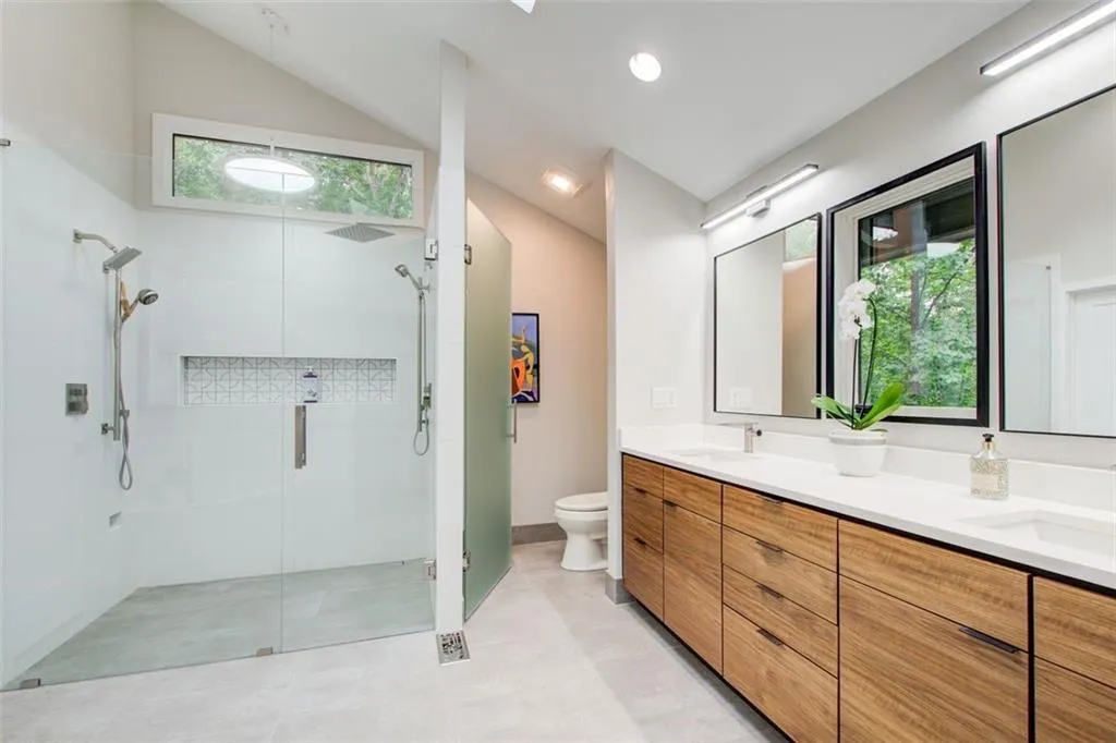 Desinger integrated 3 x 2 opening window flanked by mirrors that looks like art in this spa bathroom