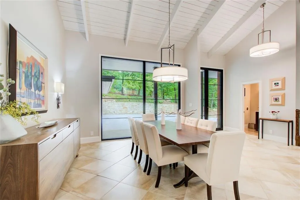 Banquet size dining room showcased by a wall of glass with designer lighting