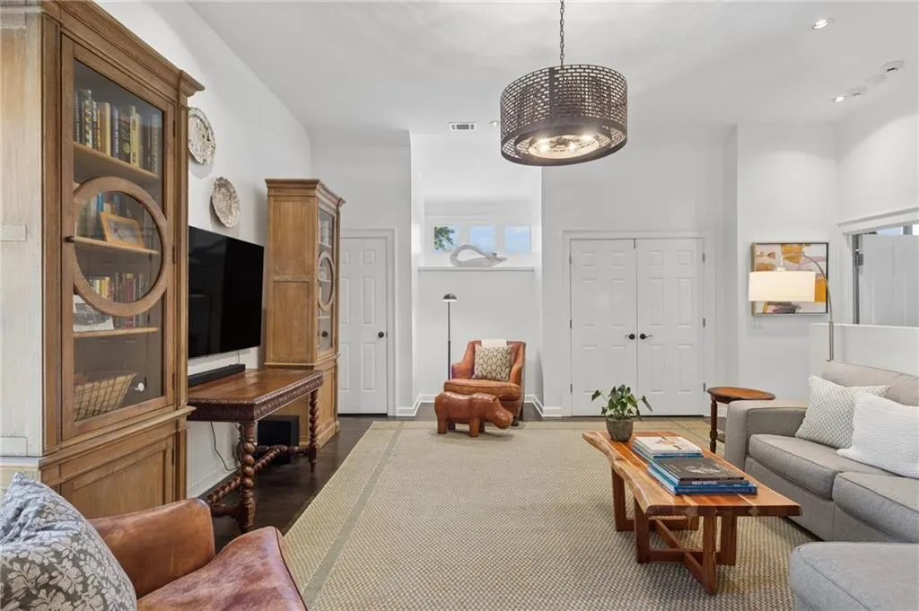 Living area featuring wood-finish flooring, recessed lighting, a decorative drum-style pendant fixture, and double-door entry