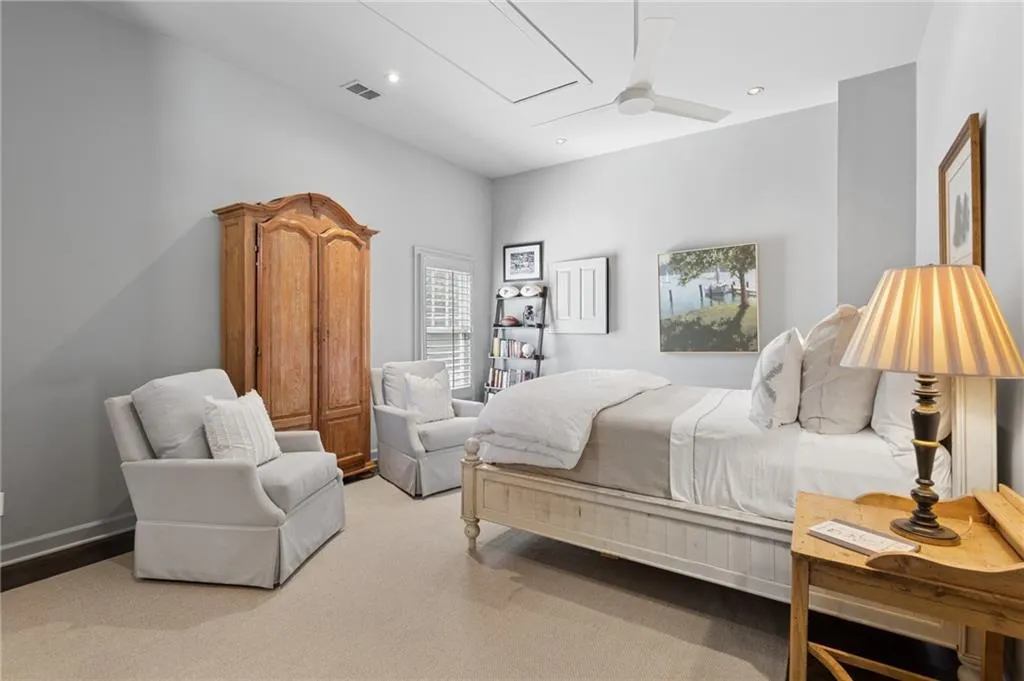Neutral-toned bedroom featuring plush wall-to-wall carpeting, recessed lighting, and a white ceiling fan