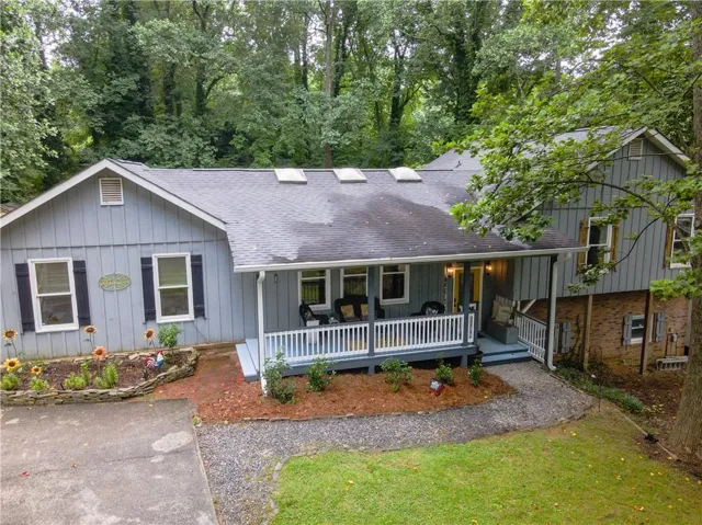 Light blue siding exterior with black shutters and a covered front porch featuring white railings