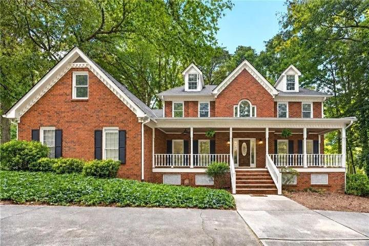 Classic red-brick home with timeless Southern charm, and a welcoming wraparound porch.