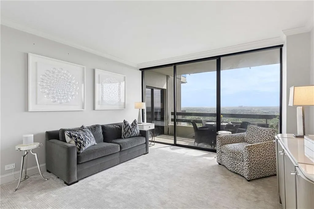 Living area featuring floor to ceiling windows, ornamental molding, and light colored carpet