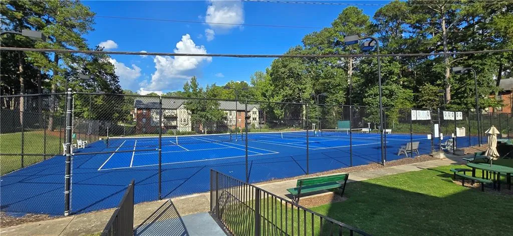 View of sport court featuring a yard