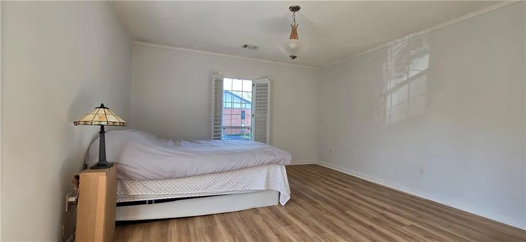 Bedroom with crown molding and hardwood / wood-style flooring