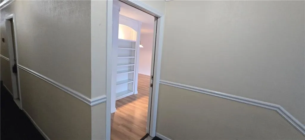 Corridor with hardwood / wood-style floors