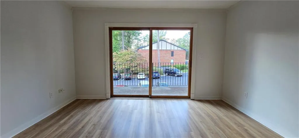 Spare room with light wood-type flooring and ornamental molding