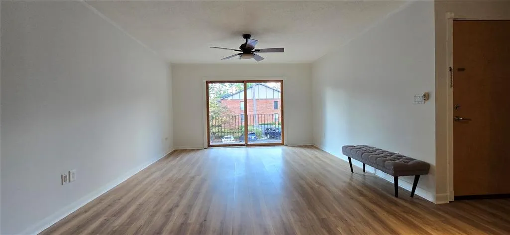 Empty room featuring wood-type flooring, a textured ceiling, and ceiling fan