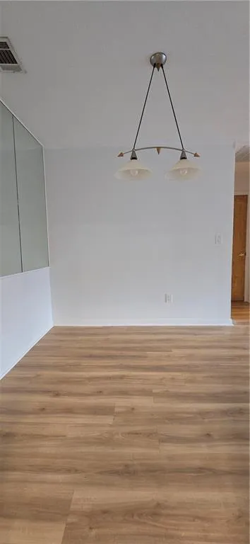 Empty room with light hardwood / wood-style flooring and a textured ceiling